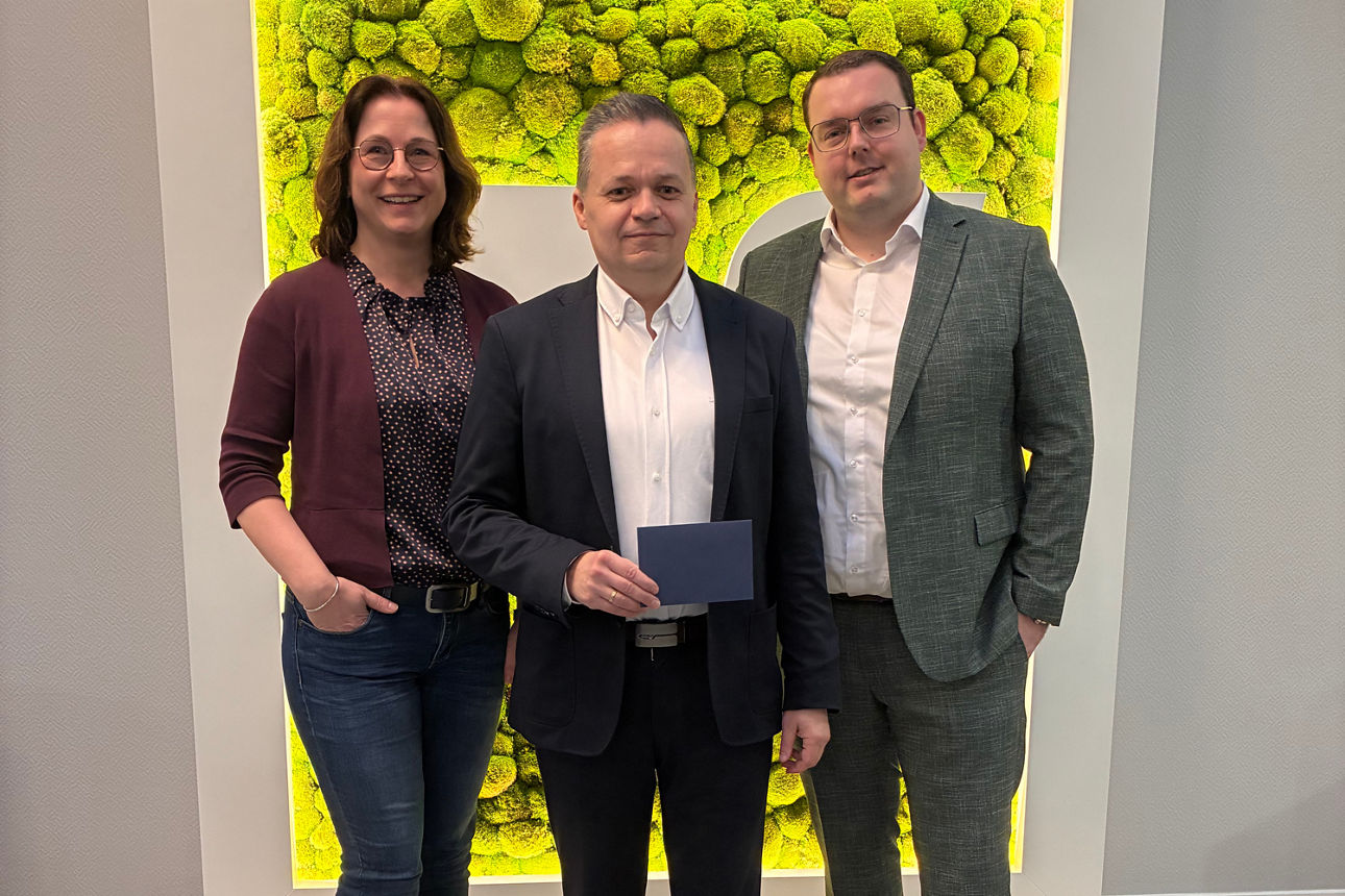 Drei Personen posieren in Innenräumen