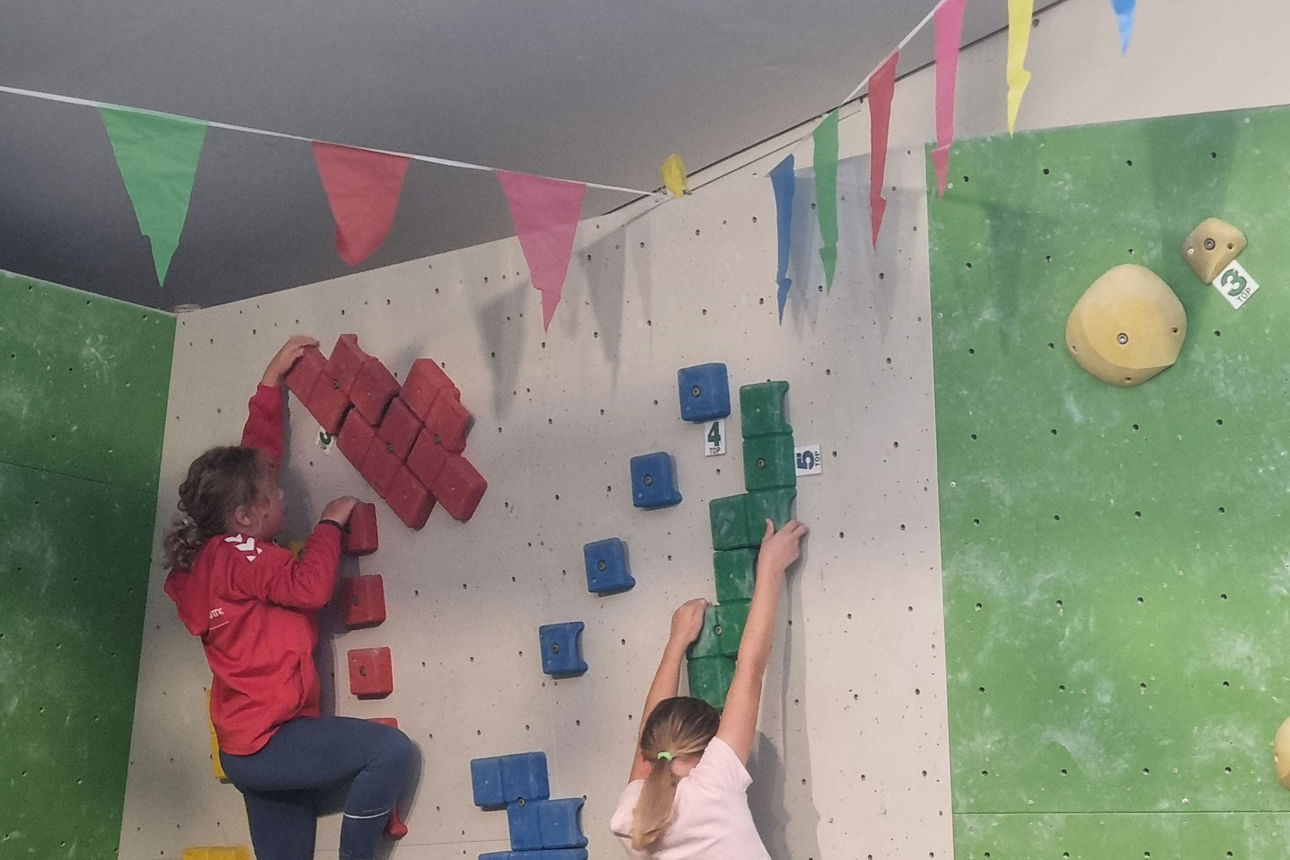 zwei Kindern bouldern an einer Boulderwand