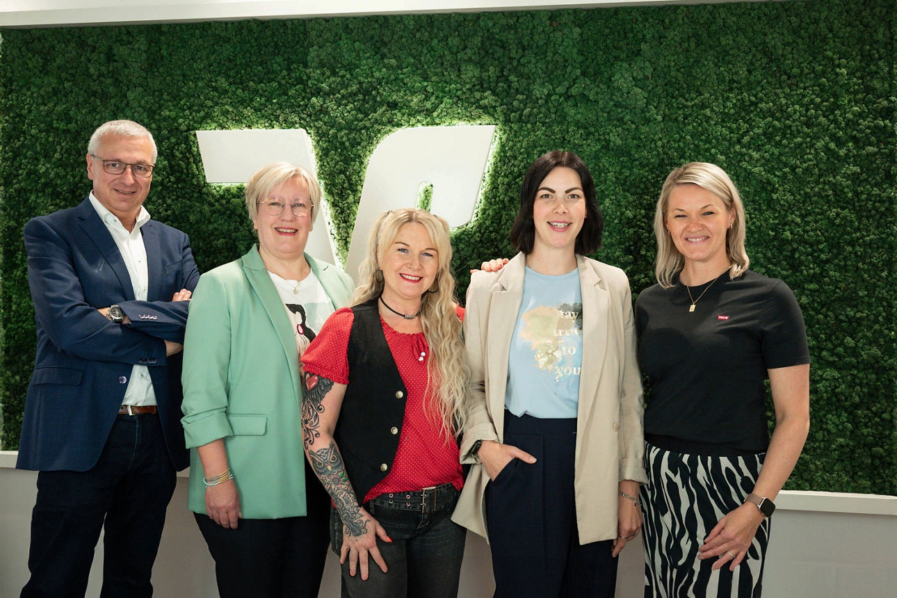 Vier Frauen und ein Mann, die schön gekleidet sind und lächeln