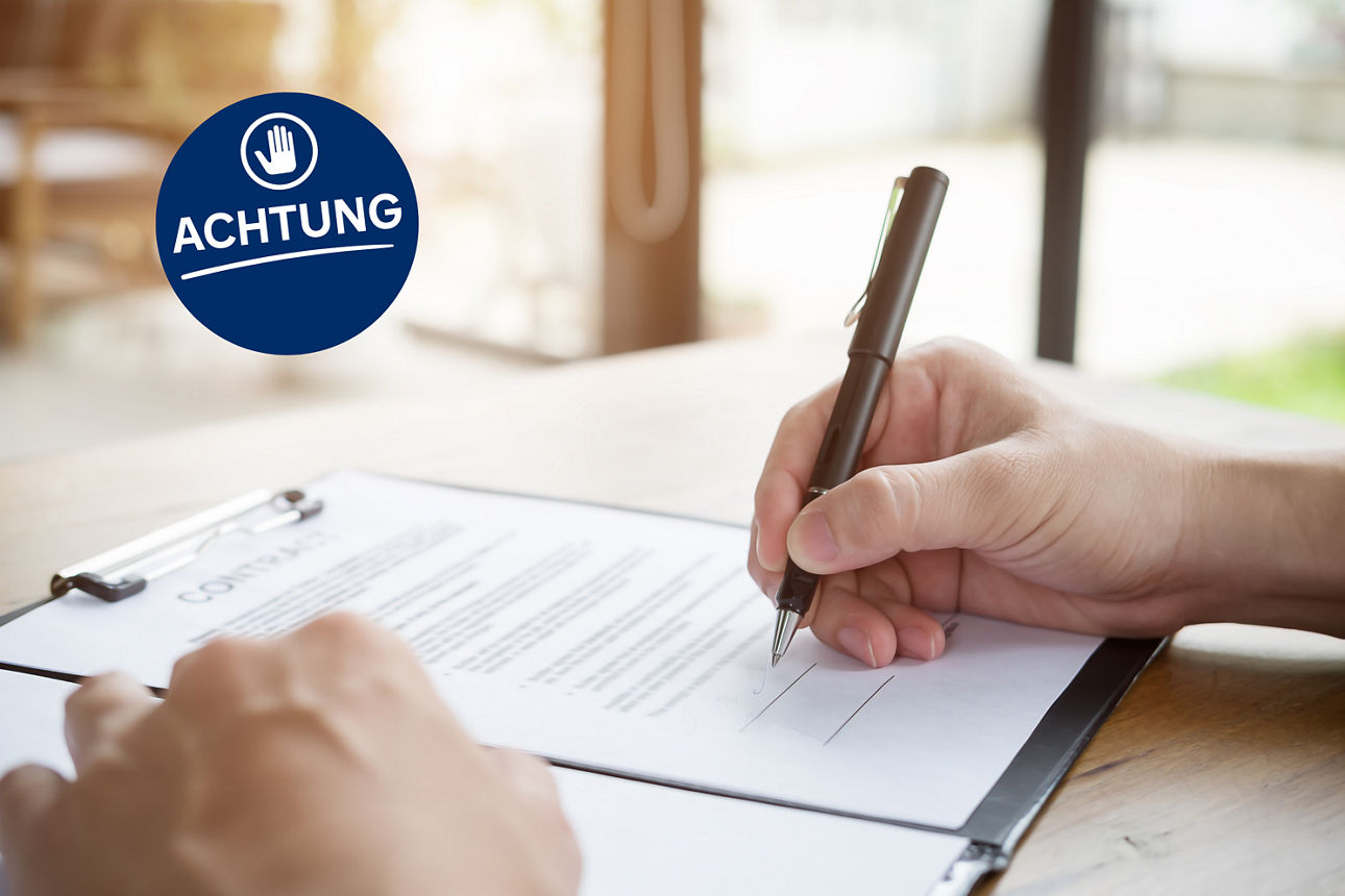 Hände die einen Vertrag unterzeichnen - Schriftzug "Achtung"