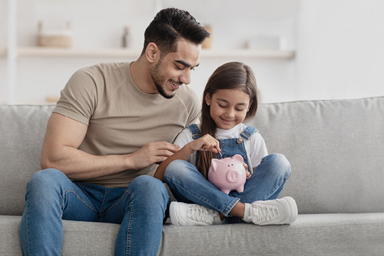 Mann sitzt mit seinem Cafe vor dem Fenster und macht entspannt seine Finanzen am LapTop und Tablet