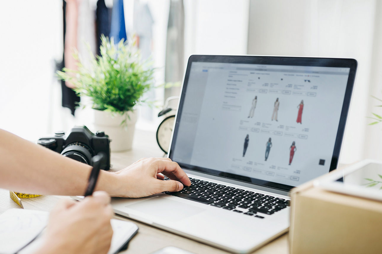 Schreibtisch mit einer Person am Laptop