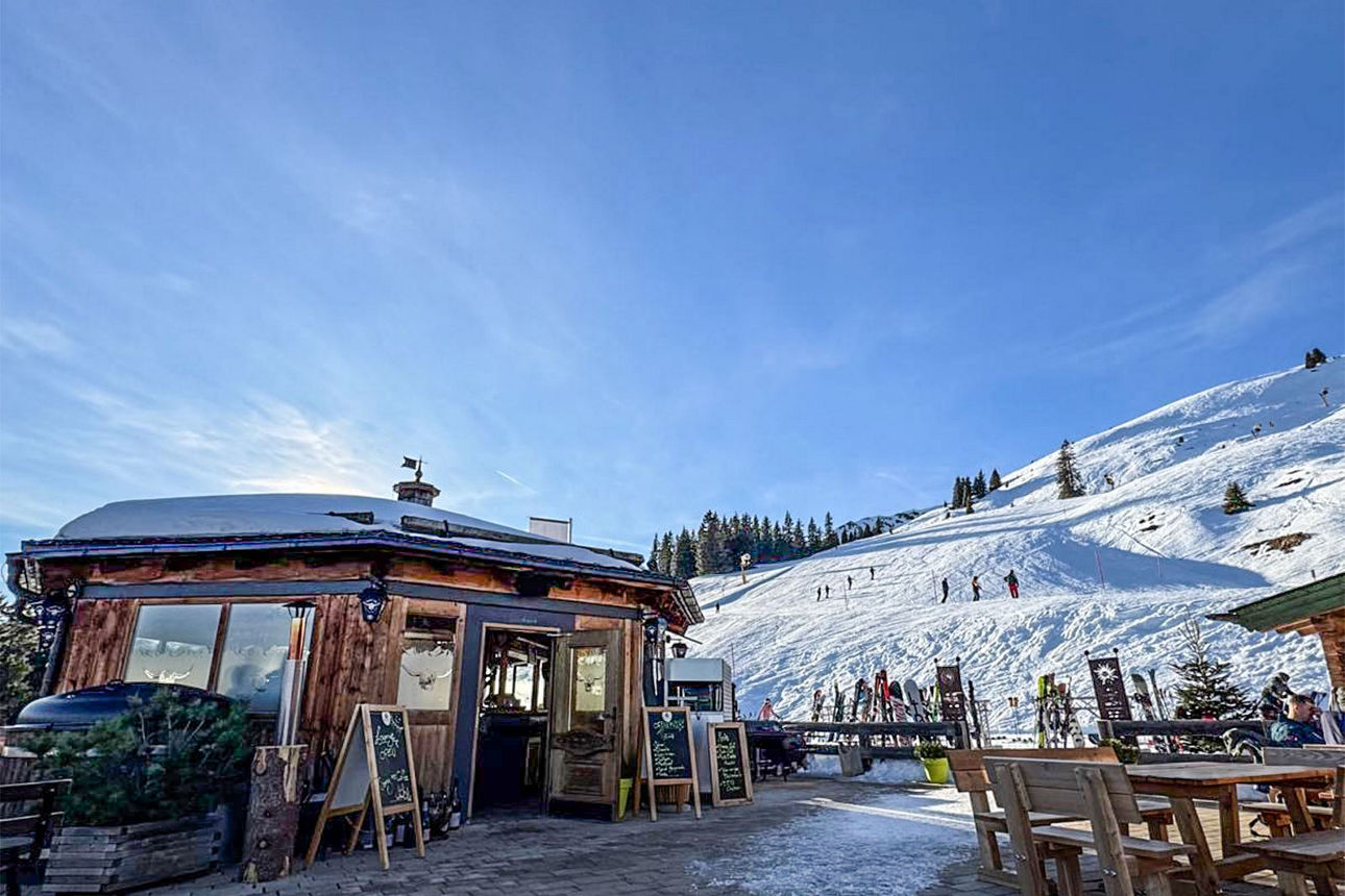 Ein Skigebiet in den Bergen mit einer Skihütte.