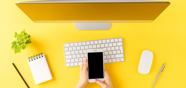 Smartphone und PC auf gelbem Untergrund