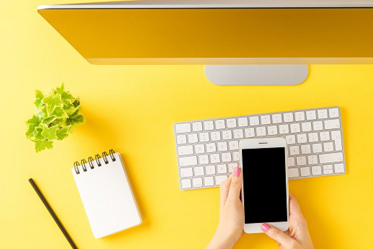 Smartphone und PC auf gelbem Untergrund