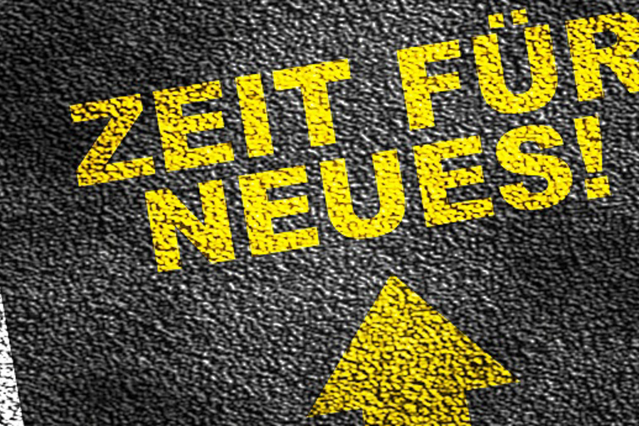 Imitation einer Straße mit Richtungspfeil und Schriftzug „Zeit für Neues!“