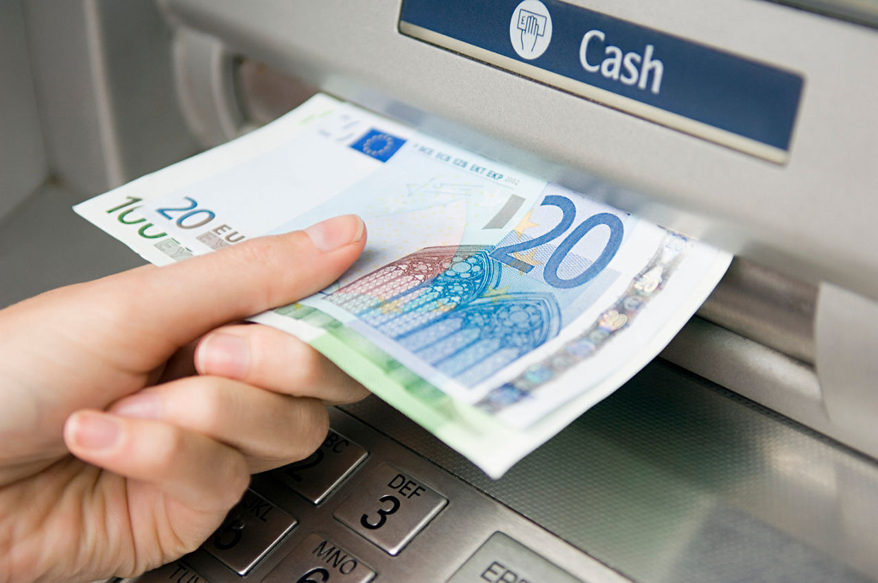 Aus einem Geldautomaten wird Bargeld entnommen
