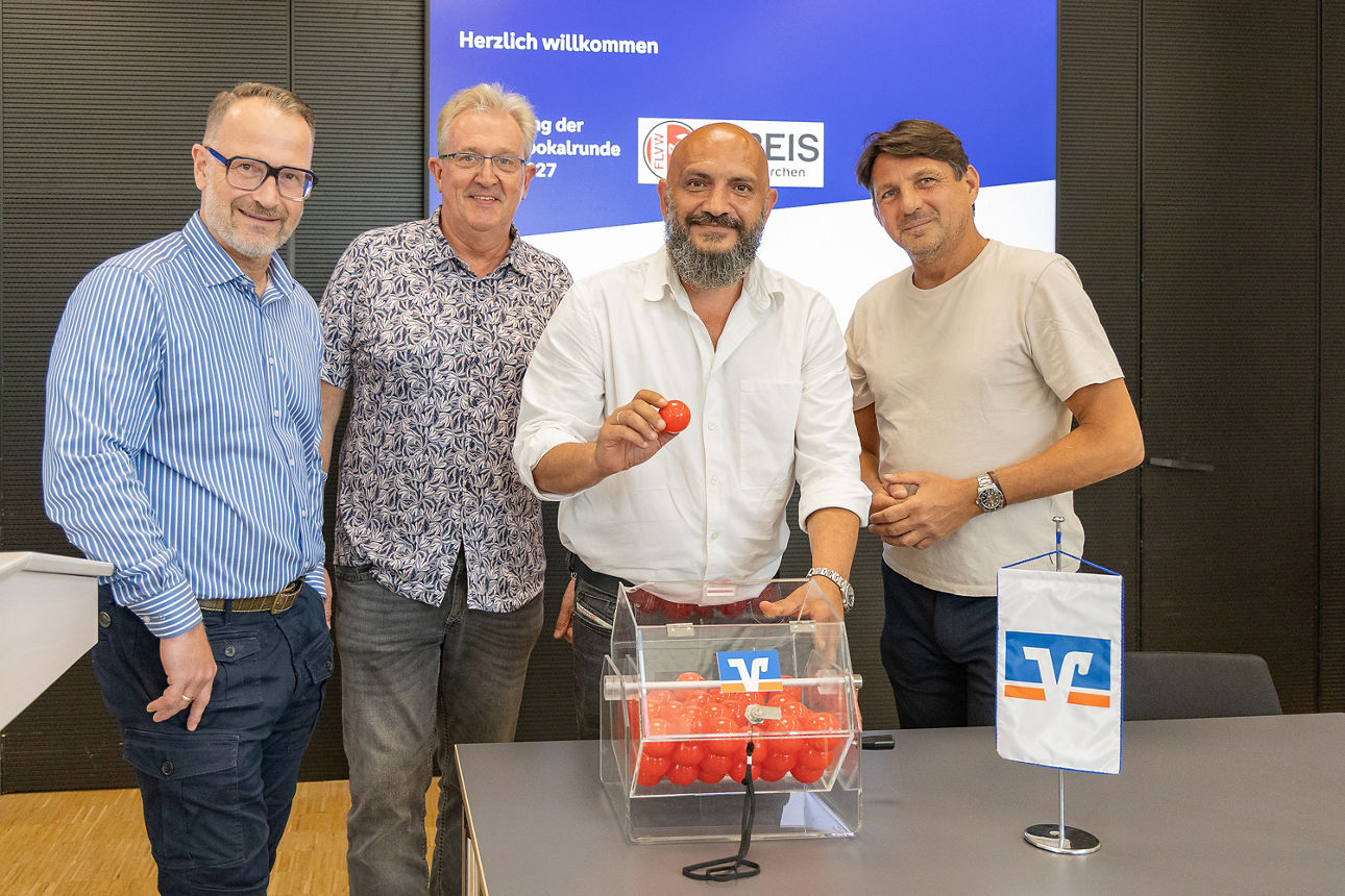 Aufnahmen aus dem Forum der Volksbank Ruhr Mitte im Zuge der Auslosung der Erstundenpartien im Kreispokal Gelsenkirchen. Es stehen vier Männer an einer Lostrommel und führen die Ziehung durch. Hinten an der Wand hängt ein Monitor.