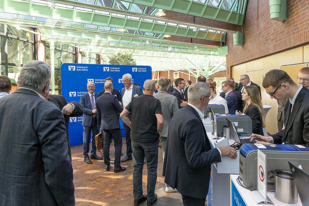 Zu sehen ist der Eingangsbereich der Stadthalle Gladbeck, der sich mit vielen Menschen gefüllt hat, die zur Vertreterversammlung der Volksbank Ruhr Mitte gekommen sind.