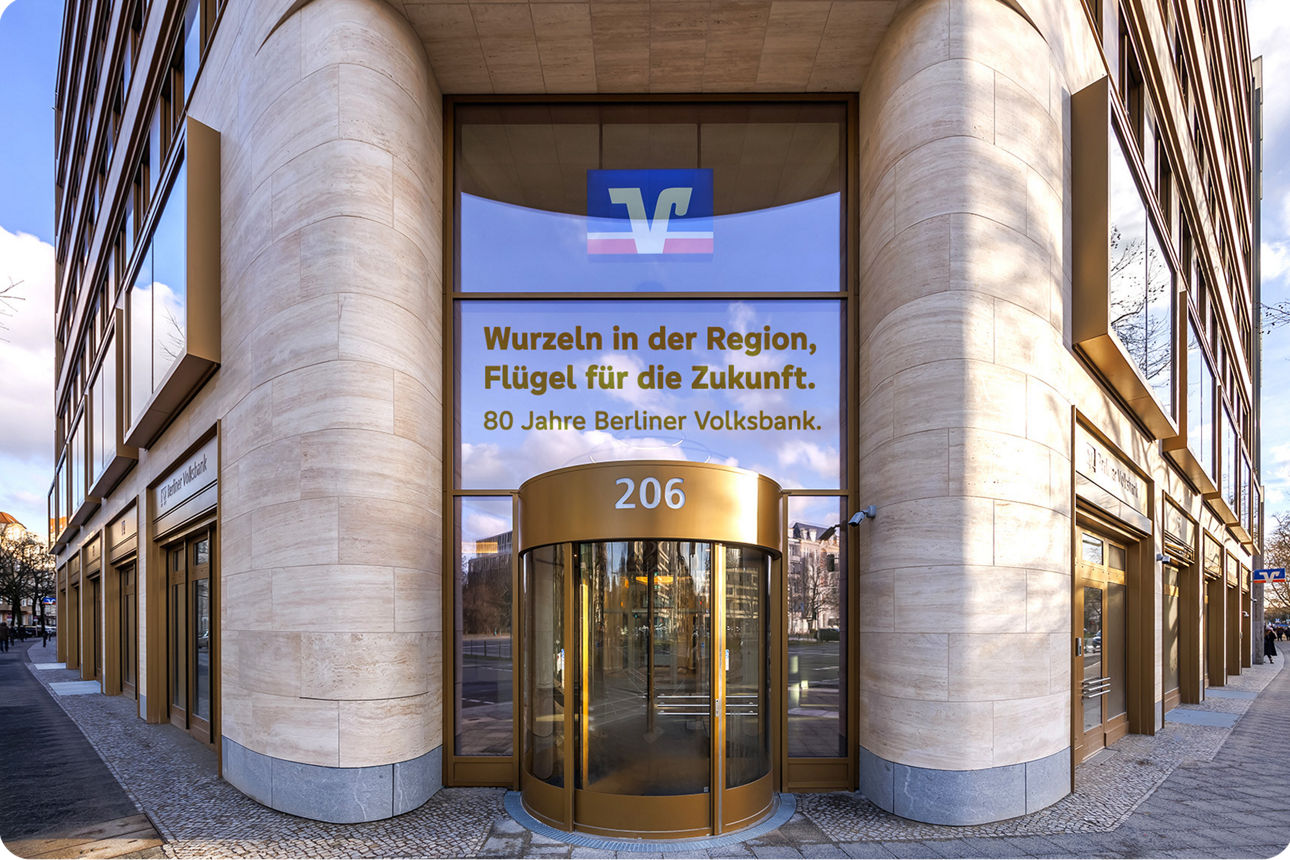 Eingang des Quartiers Berliner Volksbank mit dem Schriftzug Wurzeln in der Region, Flügel für die Zukunft. 80 Jahre Berliner Volksbank
