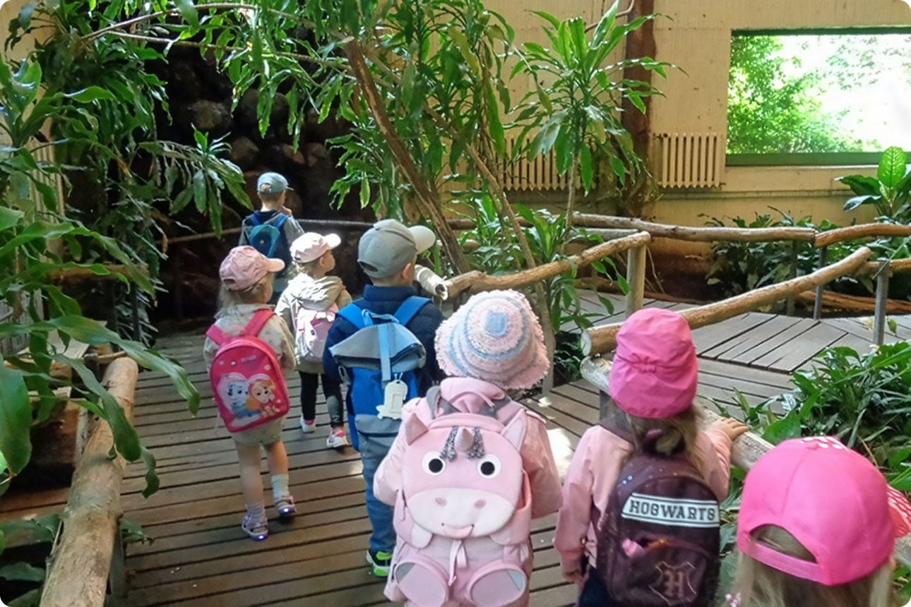 Eine Gruppe Kinder gehen durch das Krokodilhaus im Tierpark Berlin