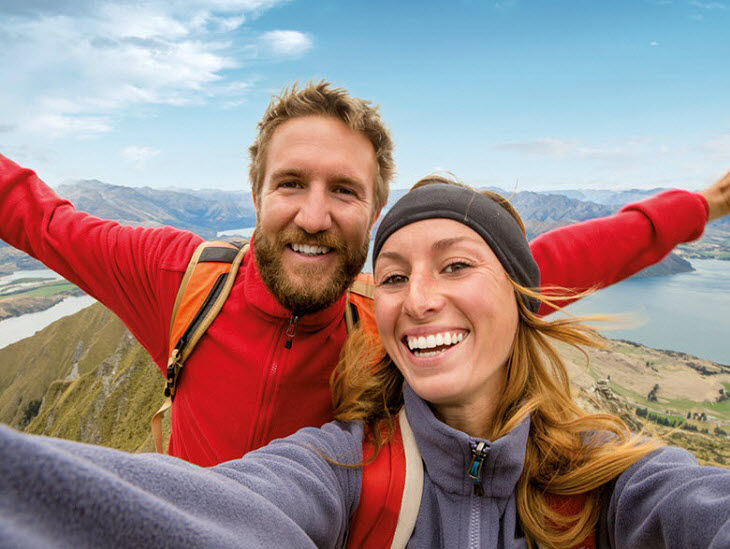 Ein Mann und eine Frau in Wanderkleidung auf einem Berggipfel