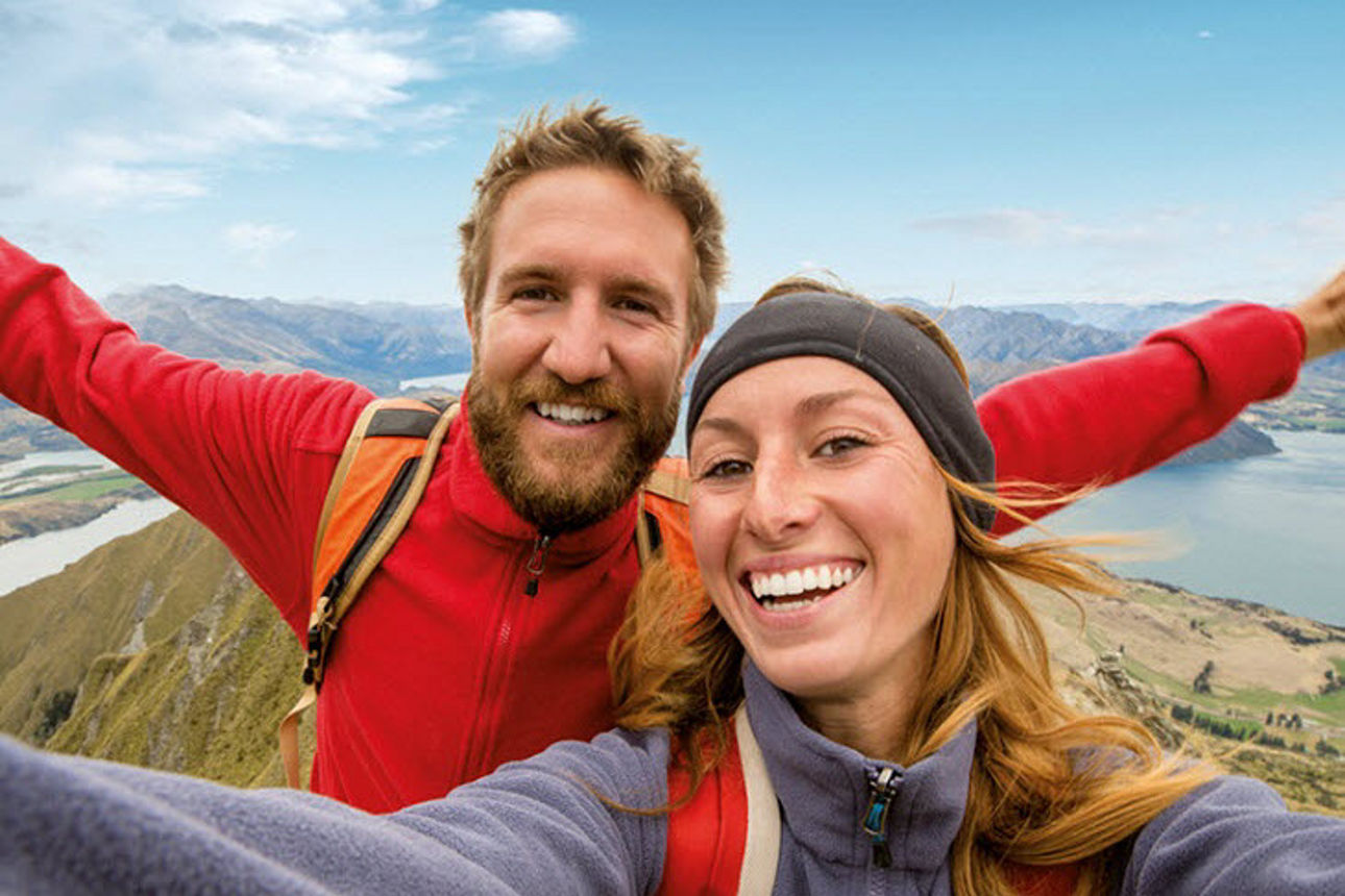 Ein Mann und eine Frau in Wanderkleidung auf einem Berggipfel