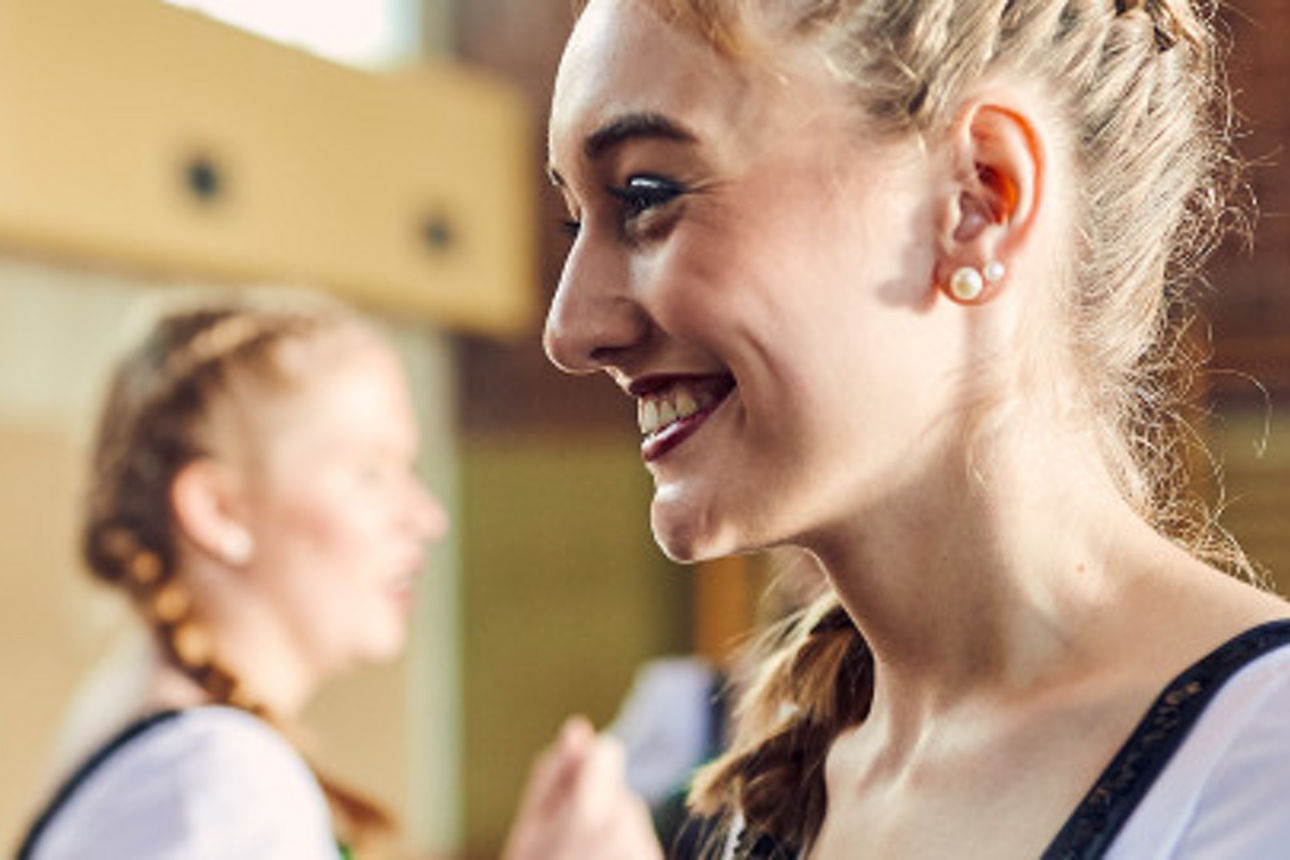 Junge Frauen mit Trachten in einer Sporthalle
