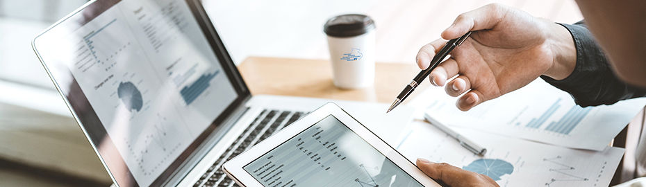 Die Person hält ein Tablet in der einen Hand, während die andere Hand einen Stift schwingt, was auf einen analytischen Prozes