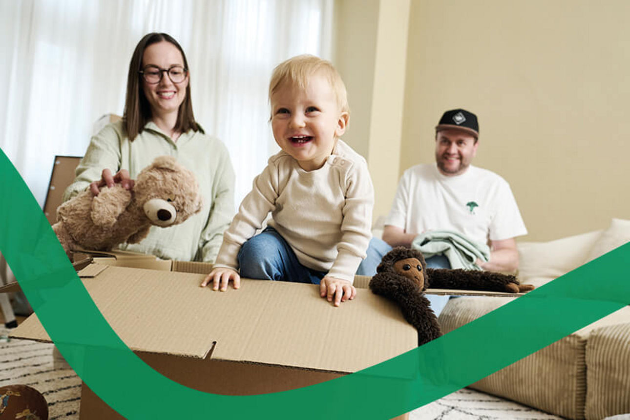 Eine Familie räumt gemeinsam Ihre Kartons aus. 