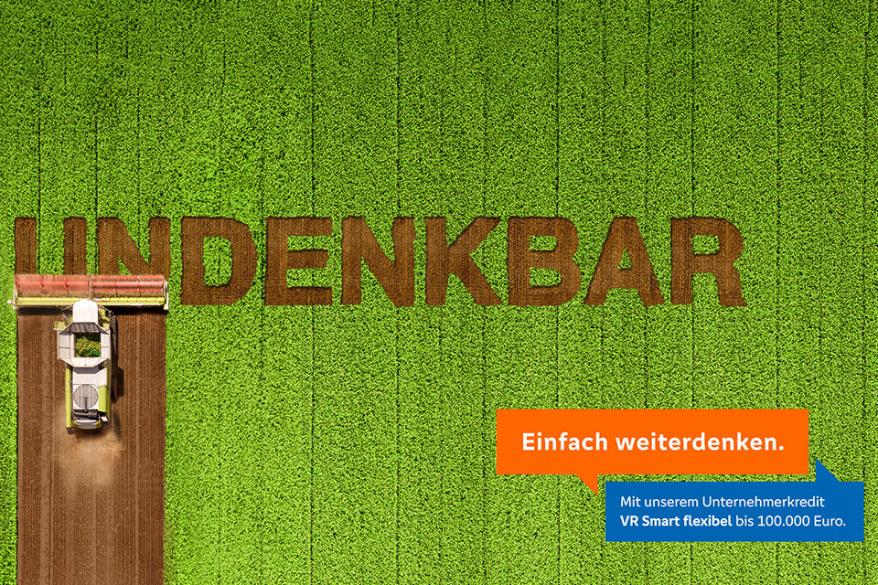 Junger Mann in Latzhose übermalt den Schriftzug „Unmöglich“ auf einer Wand