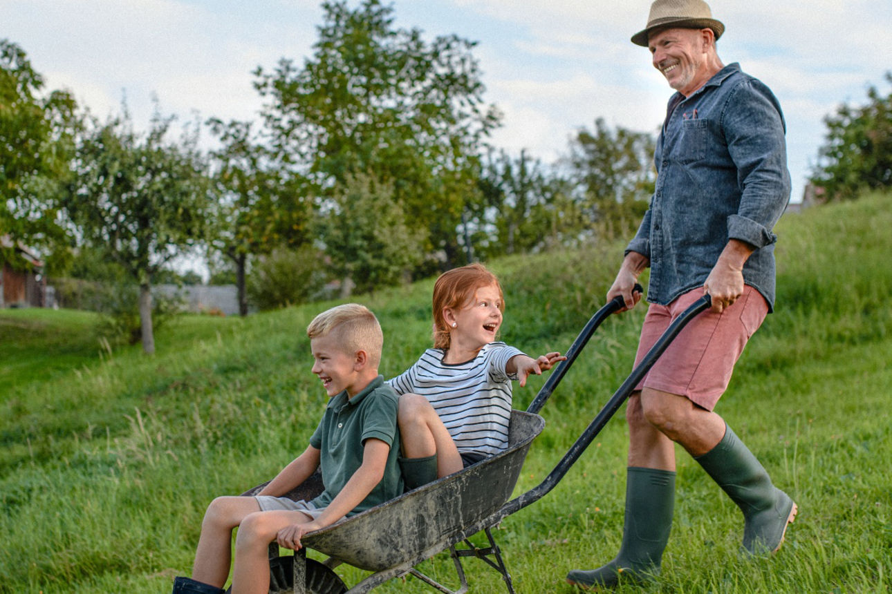 Drei Personen auf einer Streuobstwiese mit Obstbäumen und Wiesenlandschaft bei einem gemeinsamen Aufenthalt im Freien.