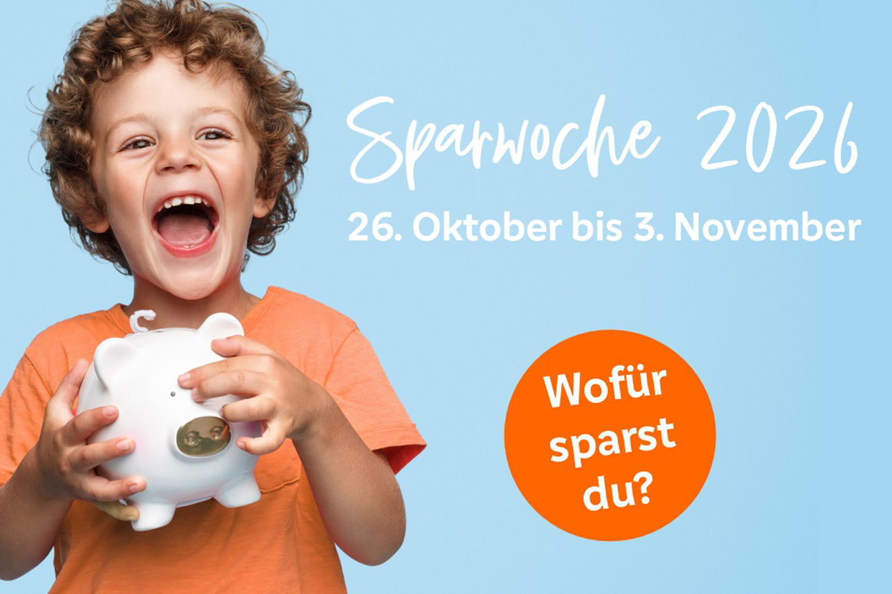 Ein kleiner Junge hält ein weißes Sparschwein in den Händen und lacht.