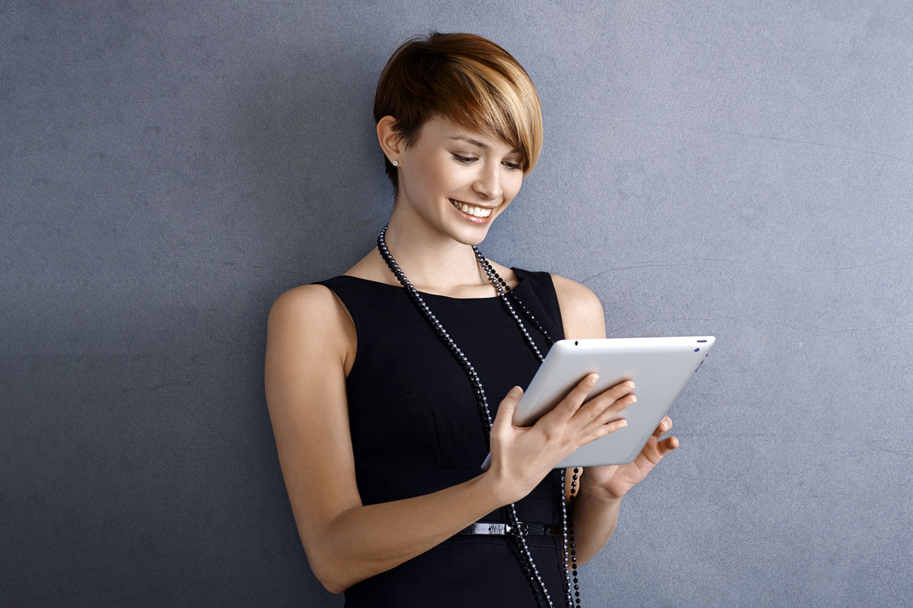 Frau mit einem Tablet am lächeln. 