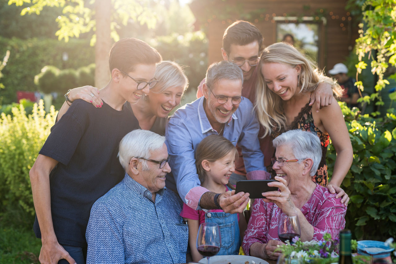Familie schaut fröhlich auf ein Smartphone 