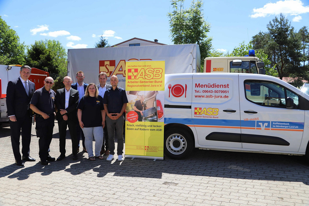 Spendenübergabe vor dem neuen Menüdienst-Wagen.