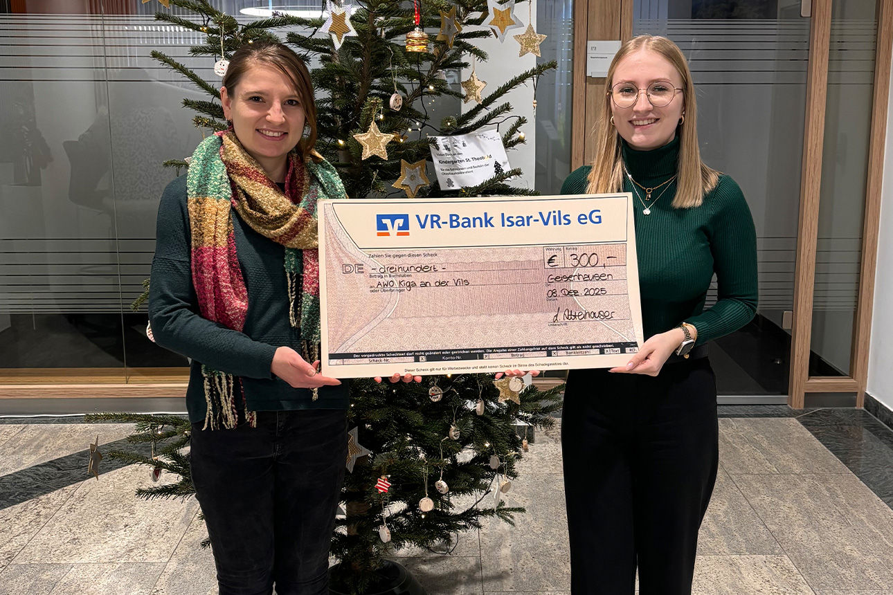 Zwei junge Frauen lachen in die Kamera. Sie halten einen Riesenspendenscheck in der Hand.