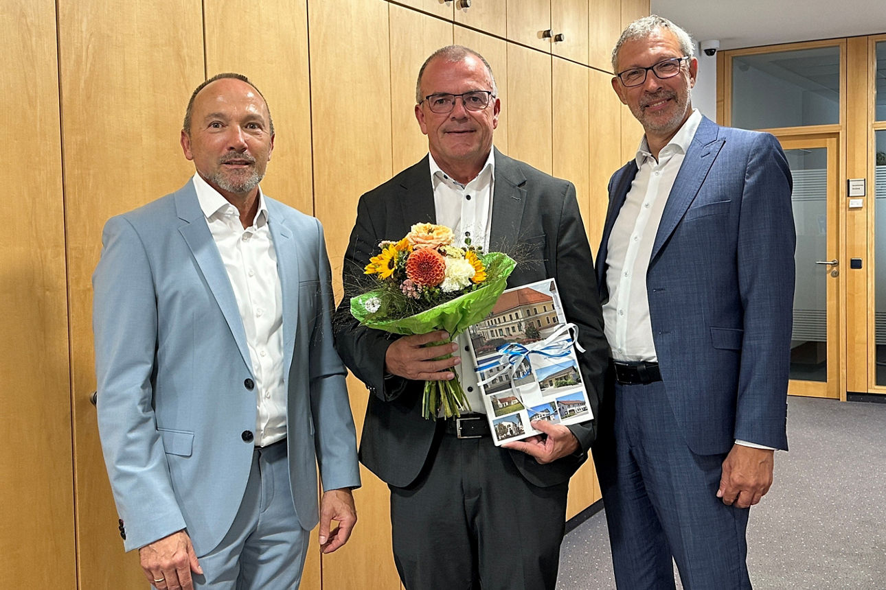 Drei Herren im Anzug in den Geschäftsräumen der Bank. 