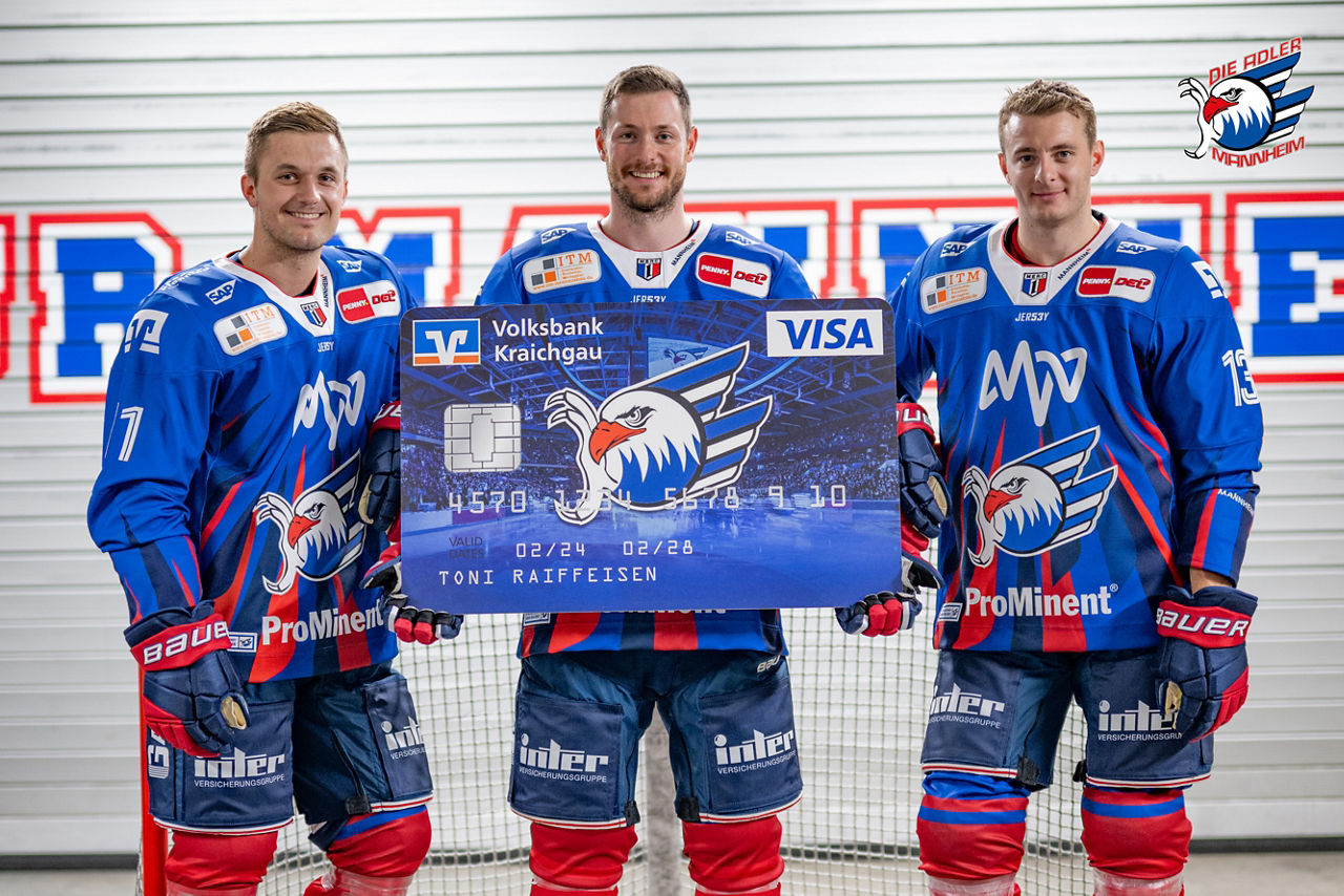 Drei Spieler der Adler Mannheim halten eine große Kreditkarte im Adler-Design.