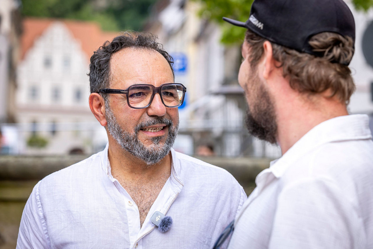 Zwei Männer im Gespräch, einer davon von vorn sichtbar
