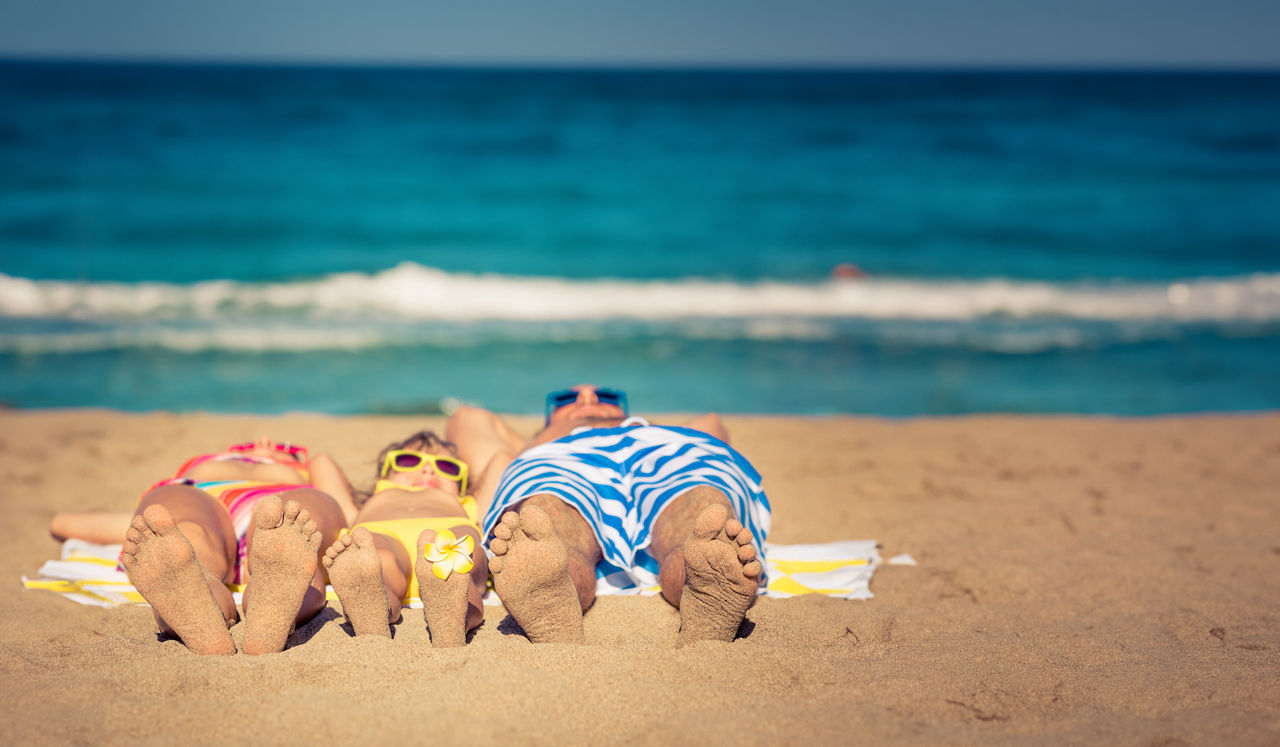 Eine Familie liegt am Strand
