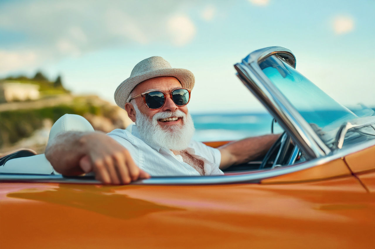 Mann schaut lässig aus einem roten Cabrio