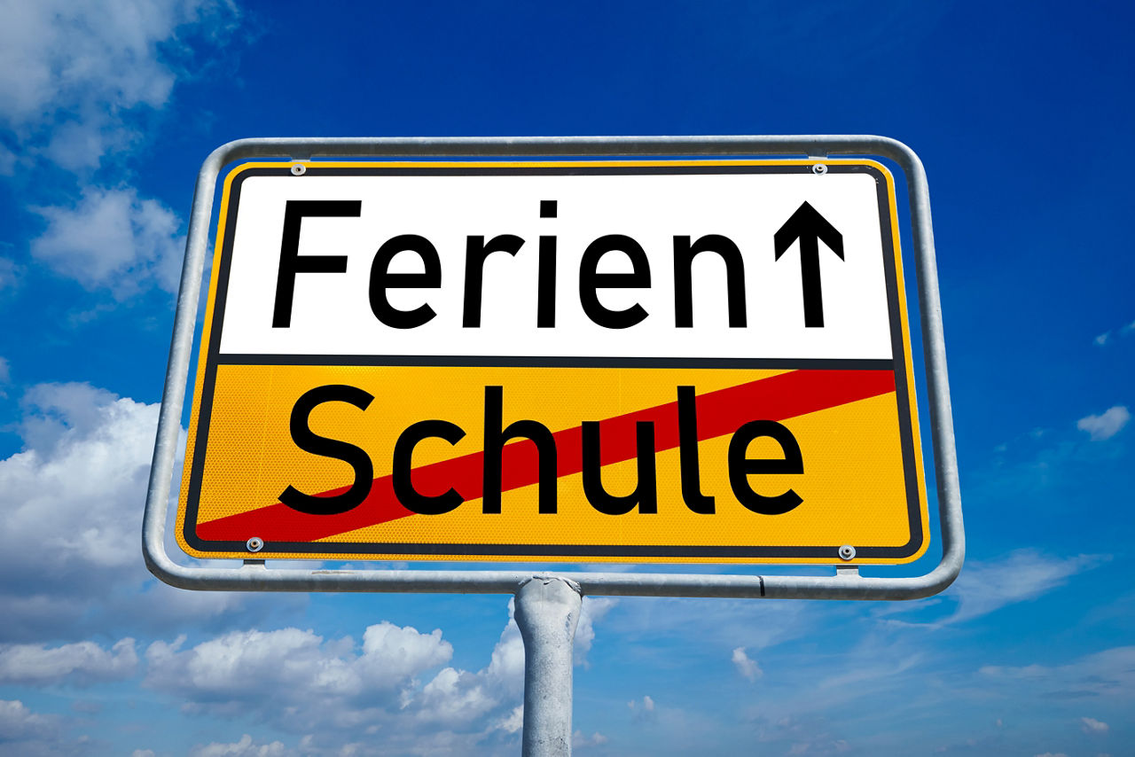 Symbolisches Ortseingangsschild mit dem Wort "Ferien" und einem Aufwärtspfeil. Darunter ist das Wort "Schule" durchgestrichen