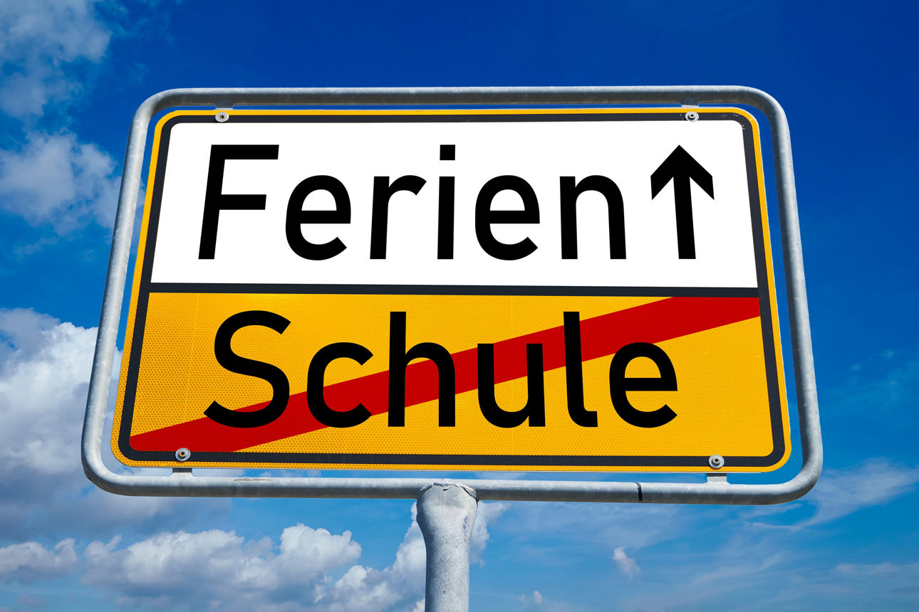 Symbolisches Ortseingangsschild mit dem Wort "Ferien" und einem Aufwärtspfeil. Darunter ist das Wort "Schule" durchgestrichen
