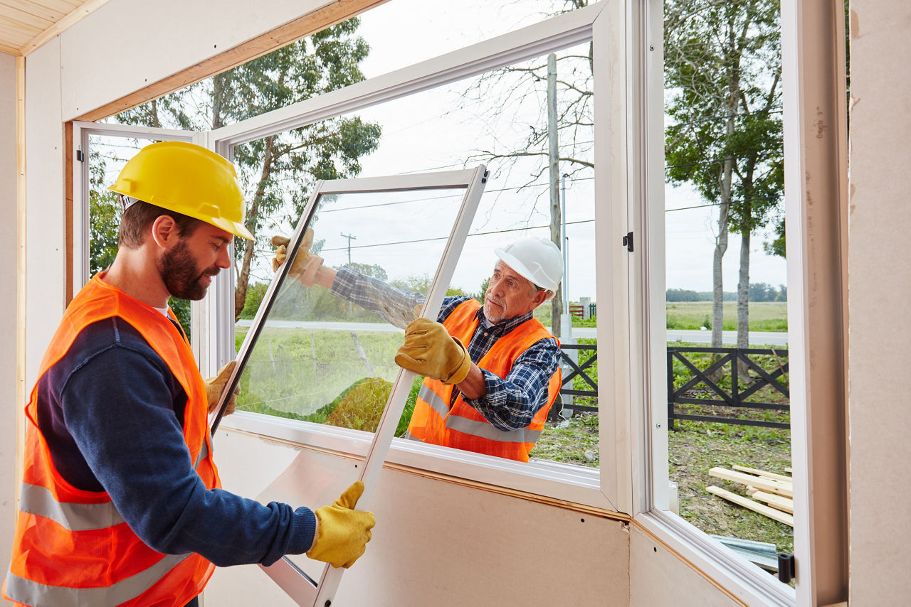 Bauarbeiter bauen neue Fenster in einem Haus ein
