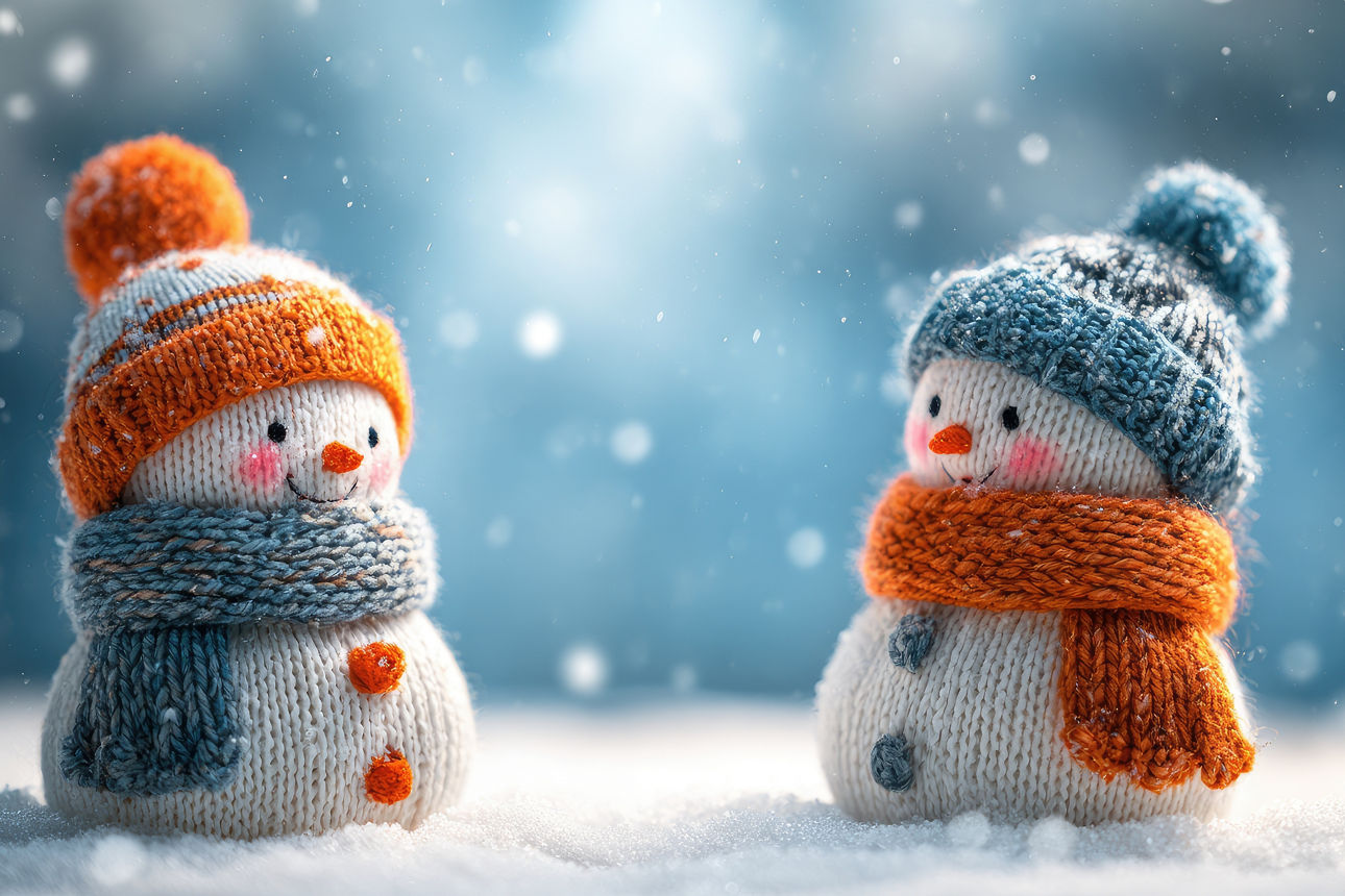 zwei gestrickte Schneemänner im Schnee