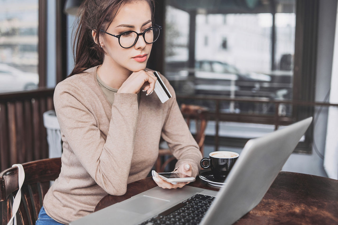 Frau mit Karte schaut in Laptop