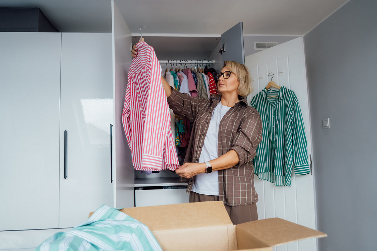 Frau mistet ihren Kleiderschrank aus