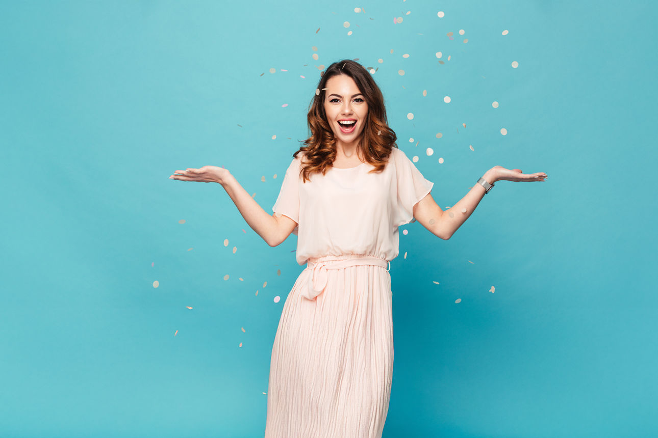 Junge Frau steht vor türkisem Hintergrund