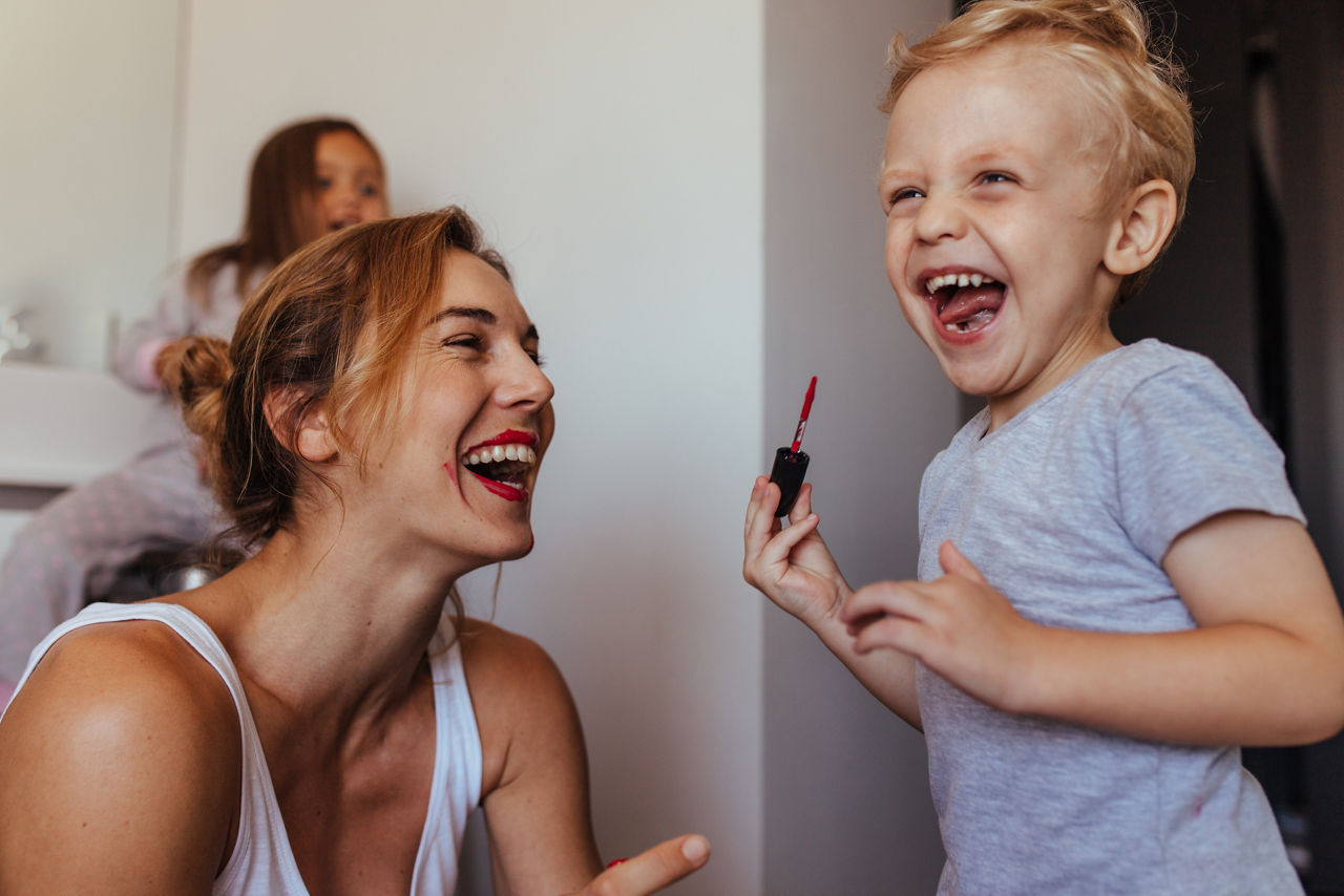 Kind malt Mutter mit Lippenstift an