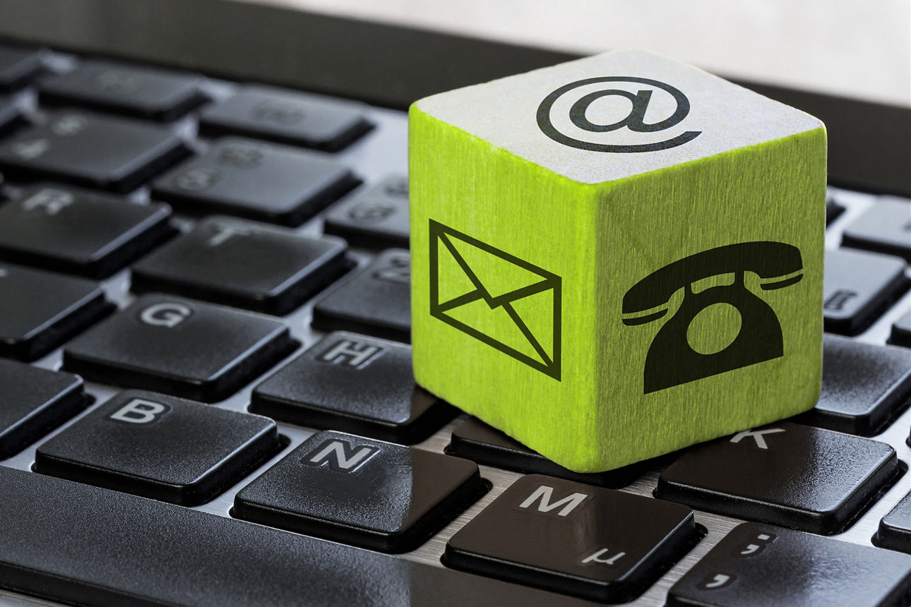 Würfel mit Kontaktmöglichkeiten liegt auf Tastatur