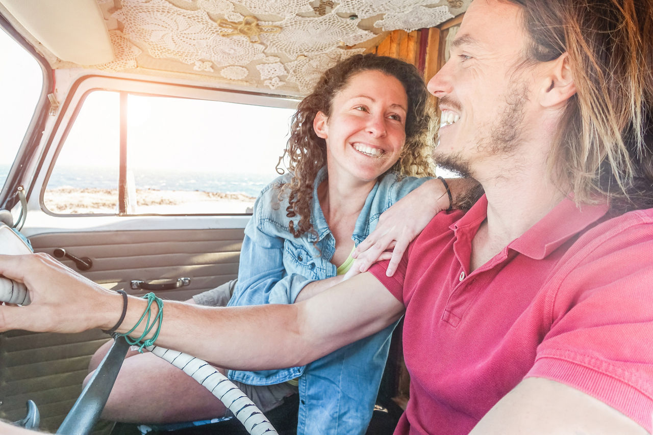 Paar fährt im Auto und legt Geld an