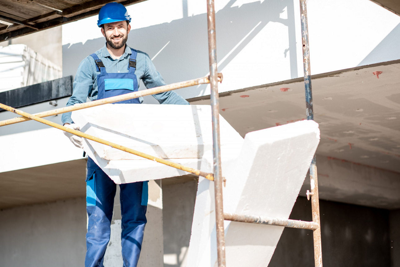 Ein Handwerker steht auf dem Gerüst