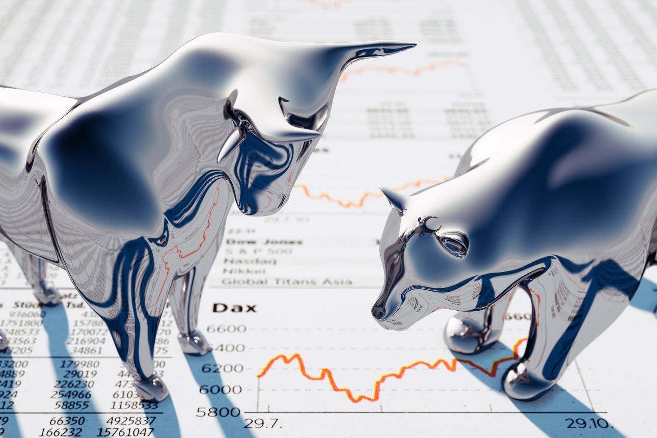 Figuren von Bulle und Bär stehen auf einer Zeitungsseite