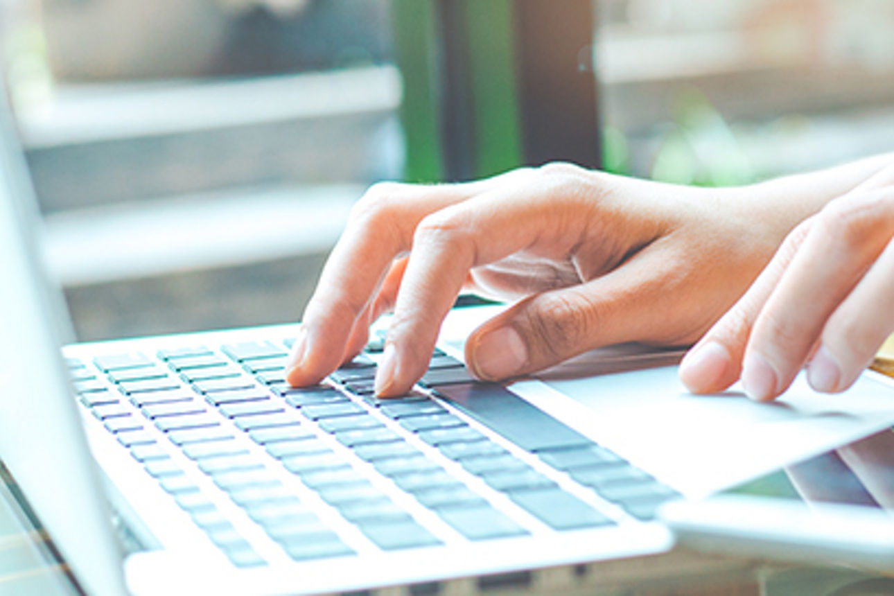Business woman working with a laptop computer and uses a cell phone in the office.Web banner.