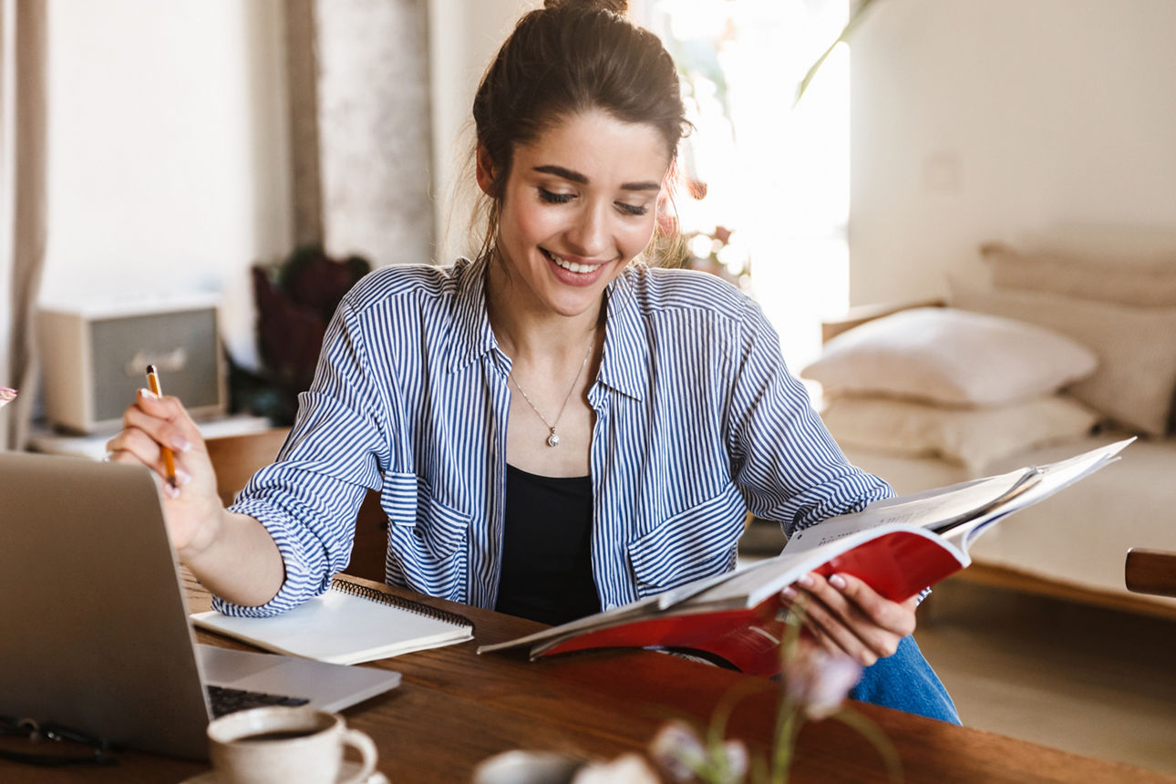 Image of caucasian pretty woman 20s in casual clothing studying with textbooks and using laptop at home