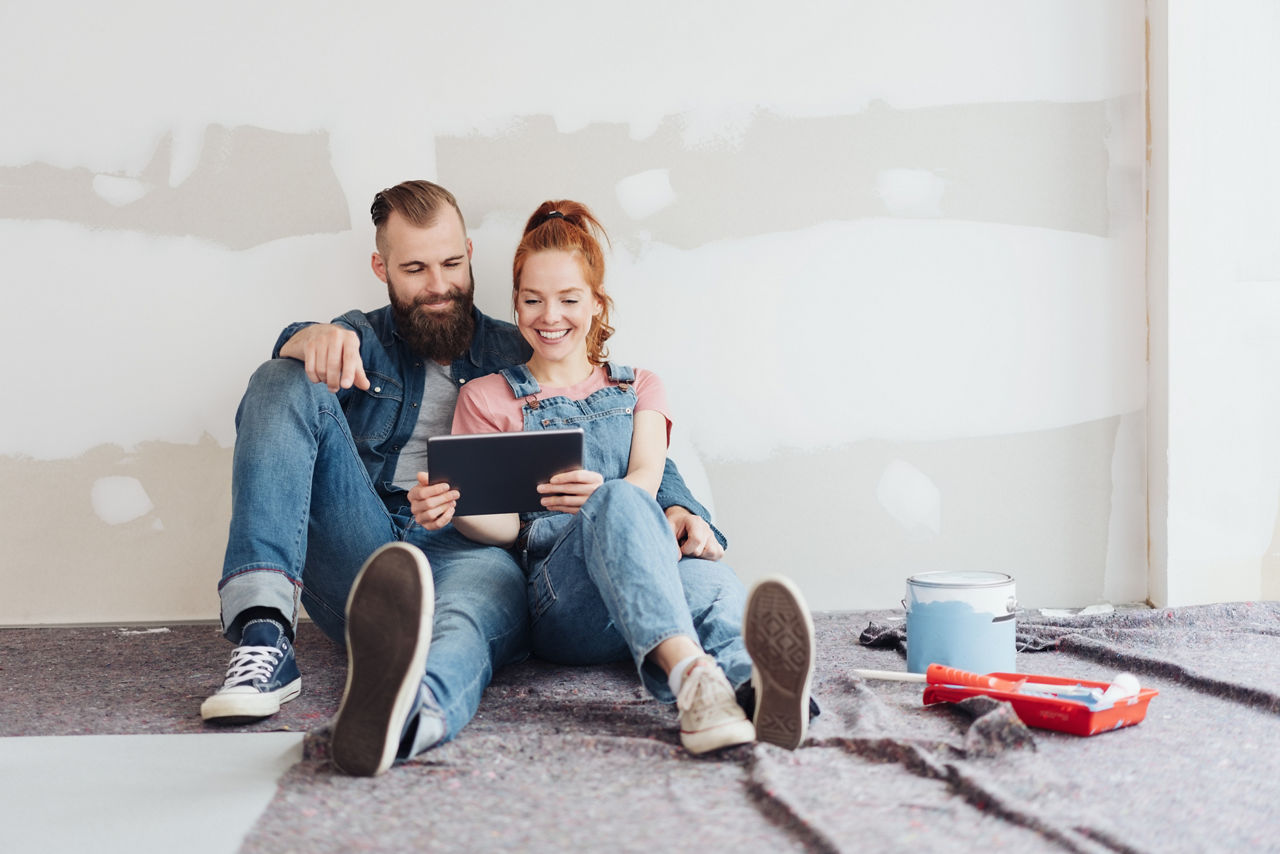 Junges Paar, das ein Haus renoviert, macht eine Pause