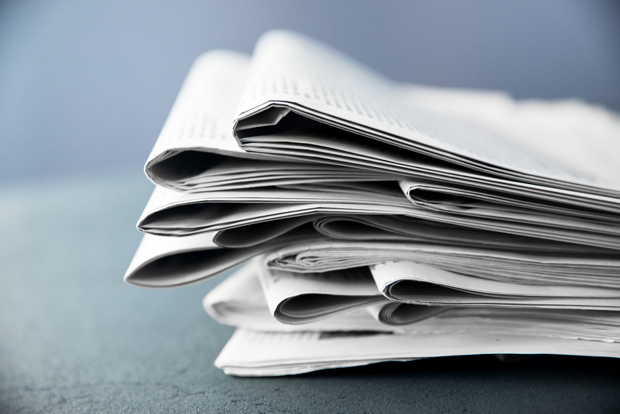 Pile of newspapers on gray background 