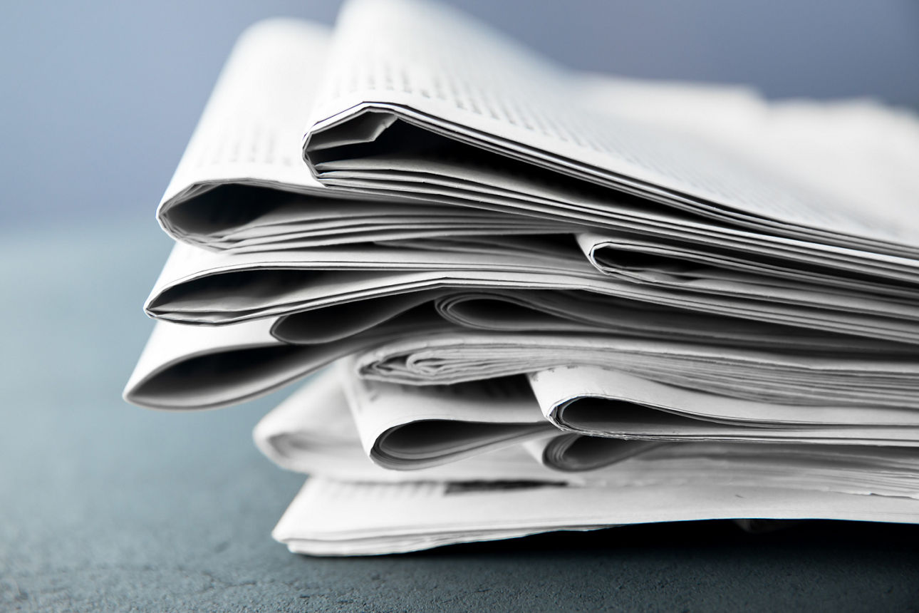 Pile of newspapers on gray background 