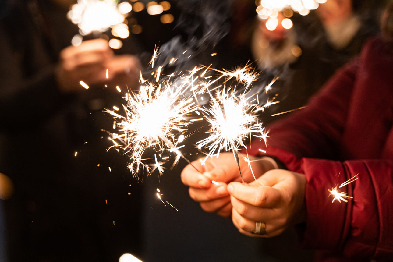 Menschen die Wunderkerzen in der Hand halten